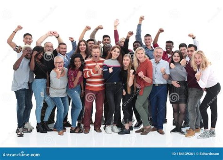 a group of people standing next to each other in front of a stadium