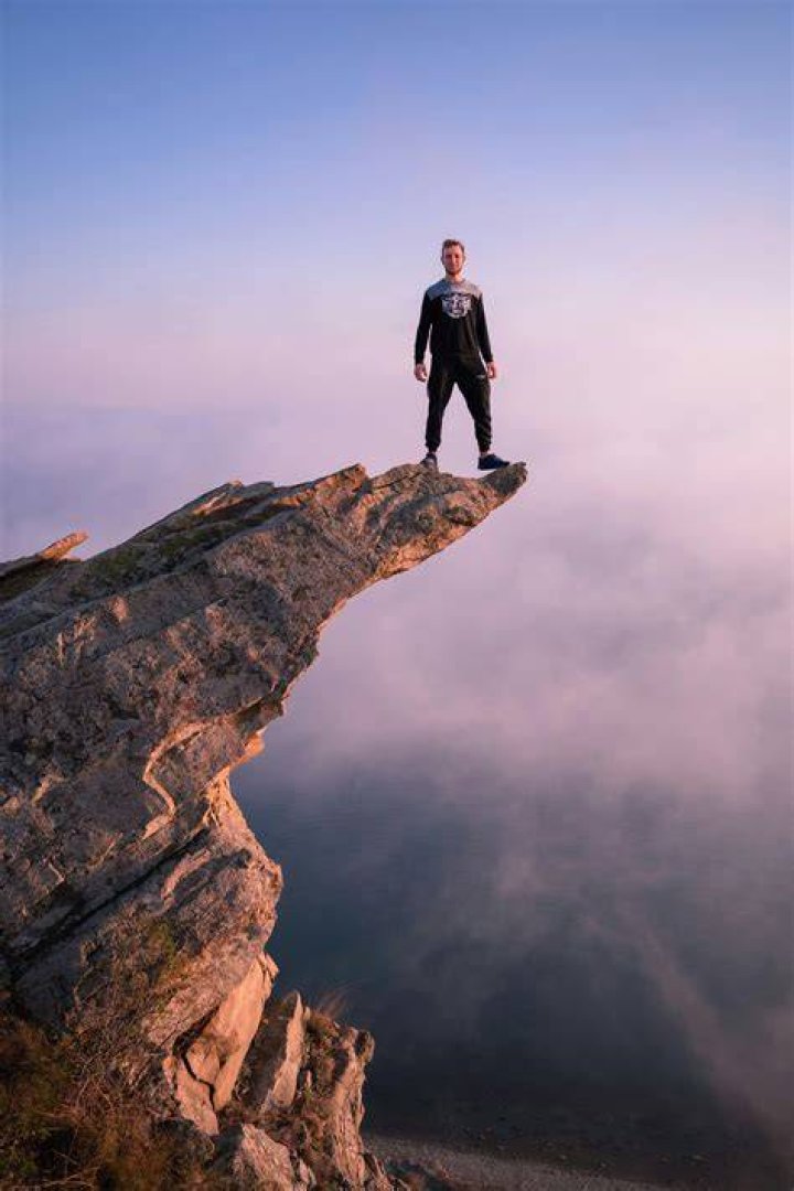 a man standing on top of a bench in a gym